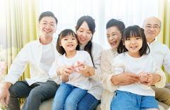 笑顔でソファに座る家族5人。親しみやすく温かい雰囲気で、会員制度の安心感を表現。